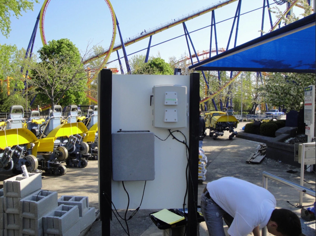 Ridelogix sensor boxes mounted on a board beside a roller coaster at Cedar Point, with cables still being run.